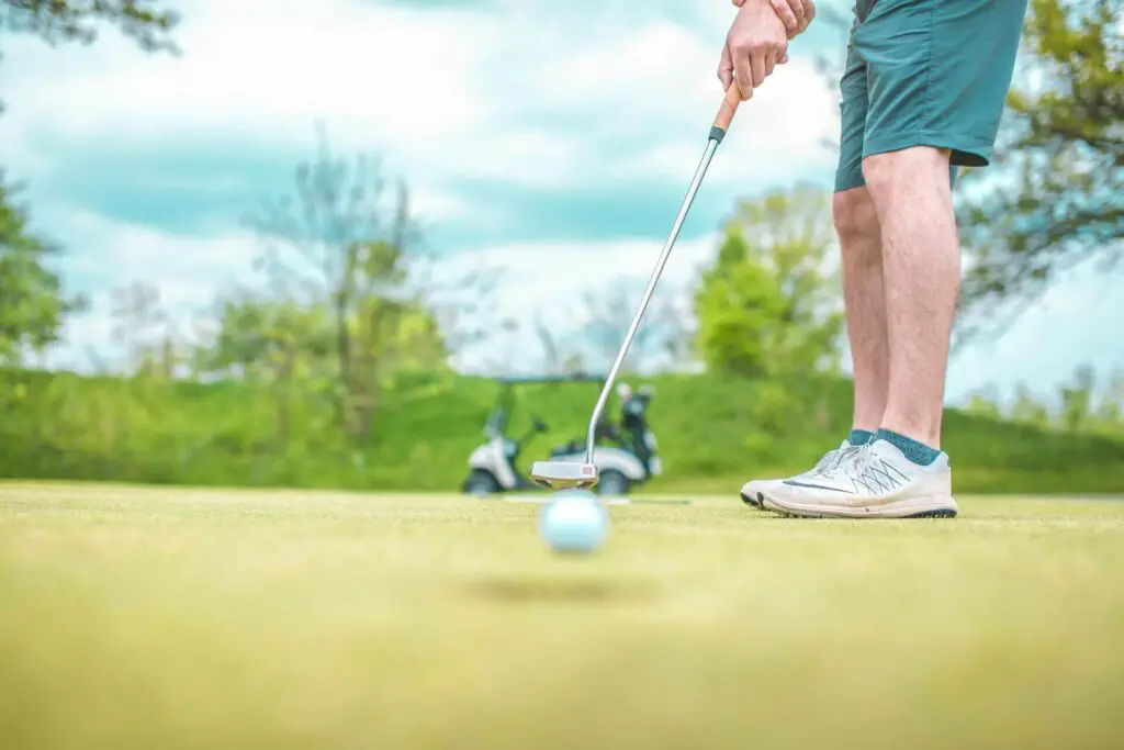 A golfer striking the ball into the hole