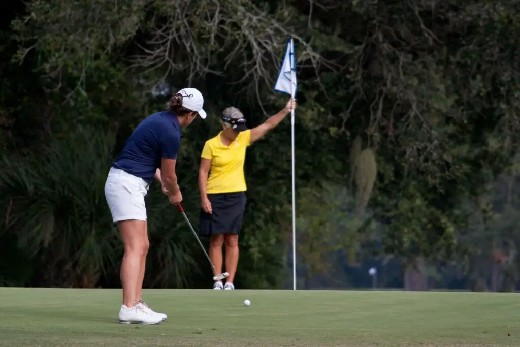 A woman swinging a golf club