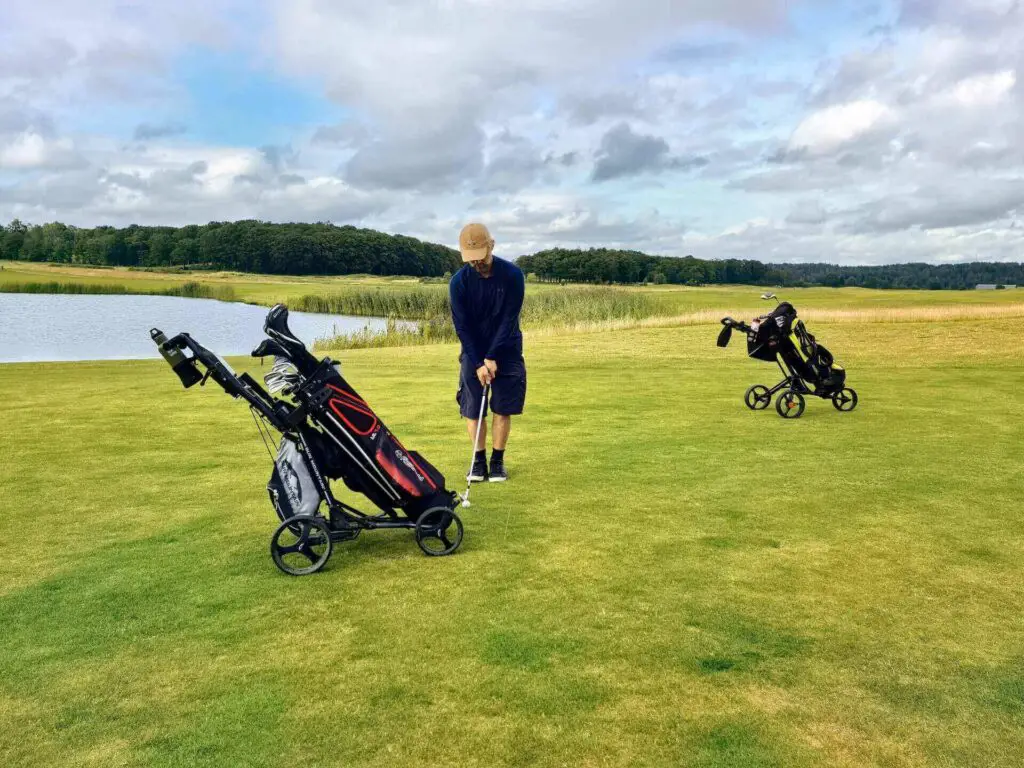  A man hitting a ball next to a push cart