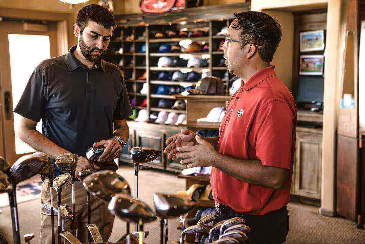 Two men consulting about golf clubs