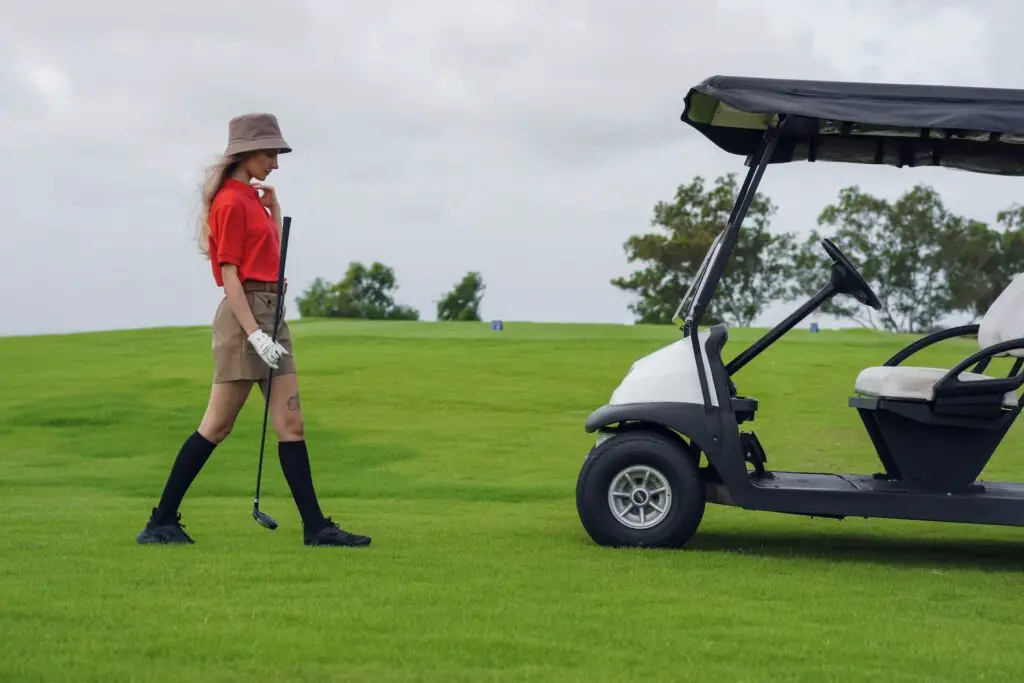 Woman on the golf course near the cart 