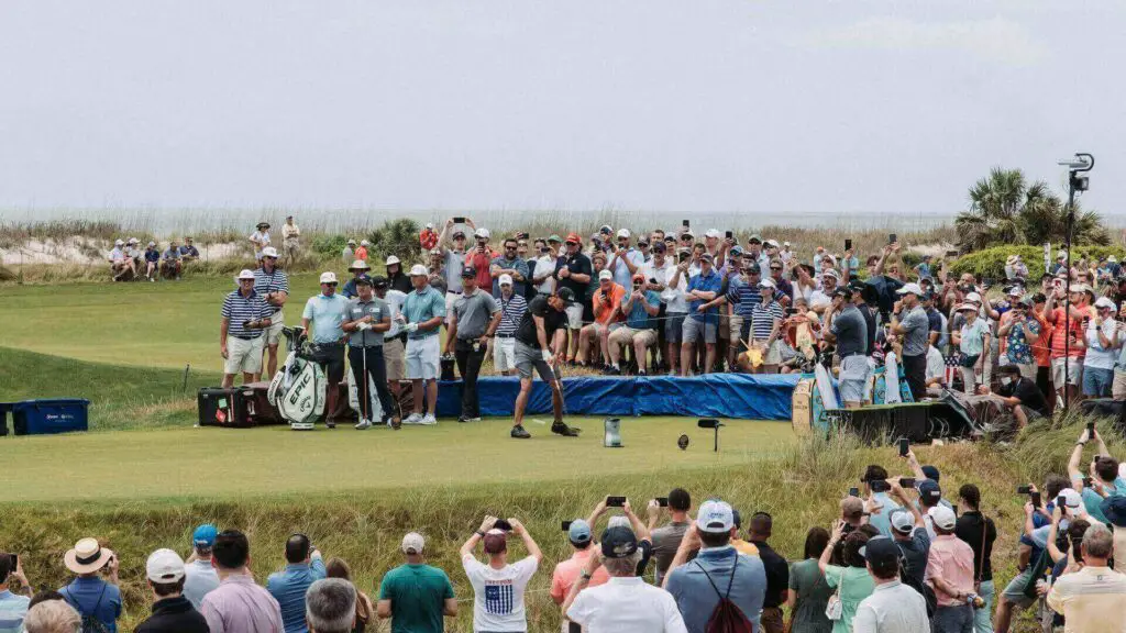 A golfer playing in a tournament, surrounded by spectators