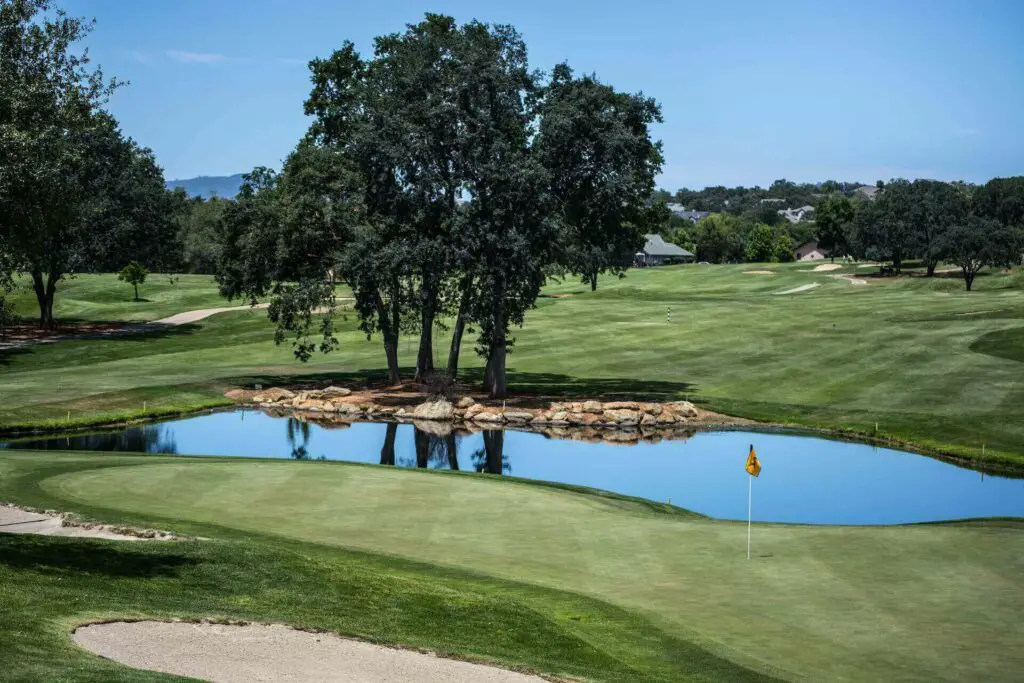  An image of a golf green with a pond and rocks