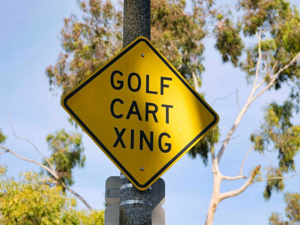 A sign for a golf cart crossing