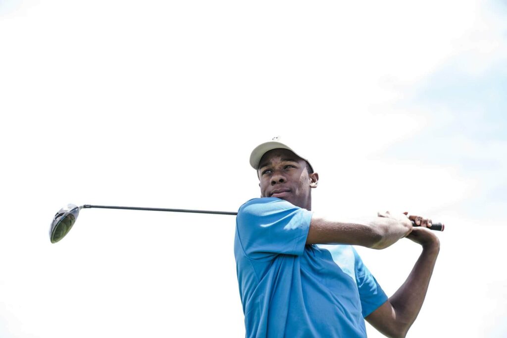 Man wearing blue shirt playing golf