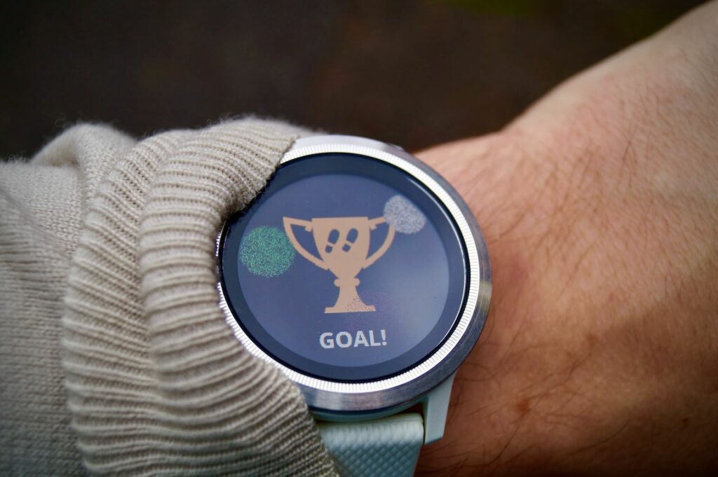 A smartwatch displaying the word 'goal' and a cup