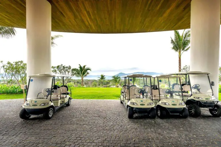Three golf carts on a hotel driveway