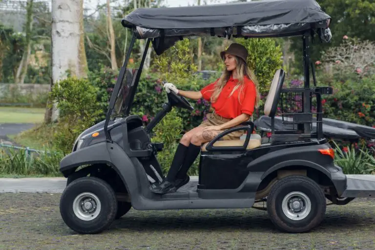 A girl sitting in a parked golf cart