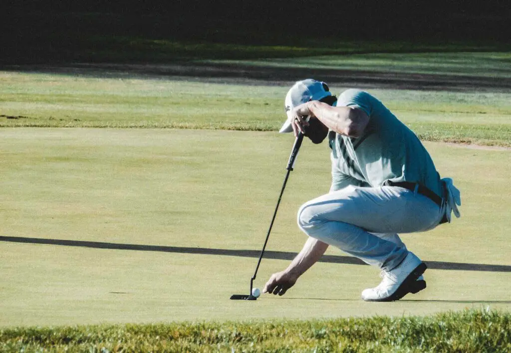 A golfer picking up his ball