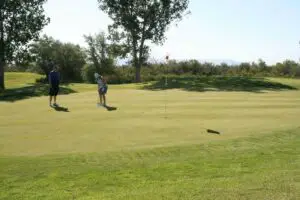 A man and a woman golfing on the course