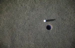 A golfing ball near a hole
