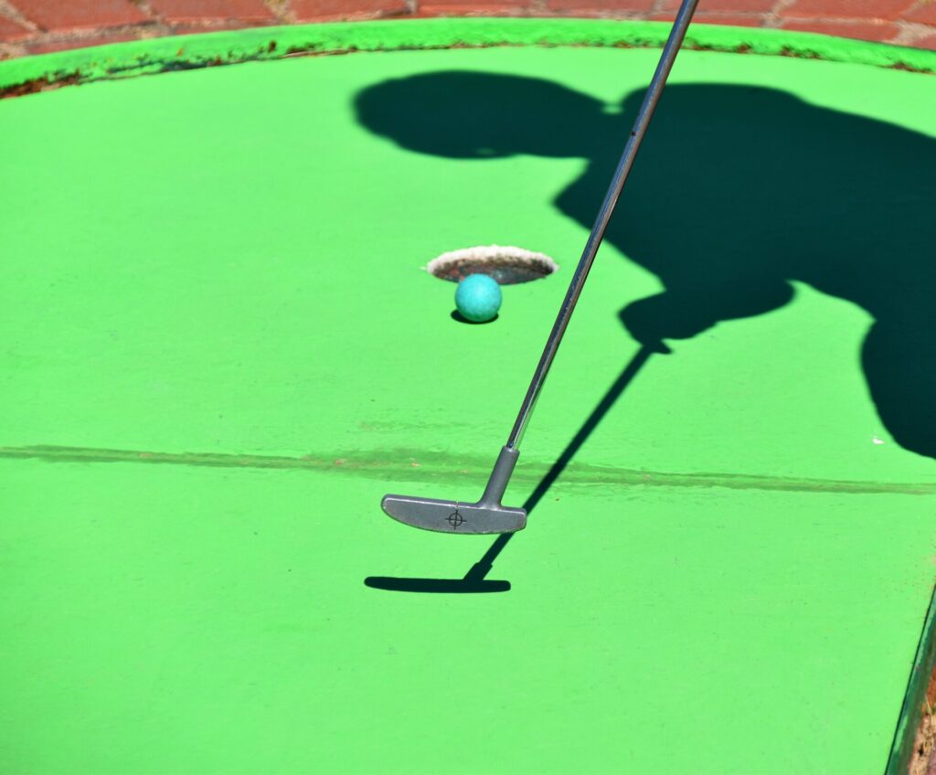 A person playing mini golf
