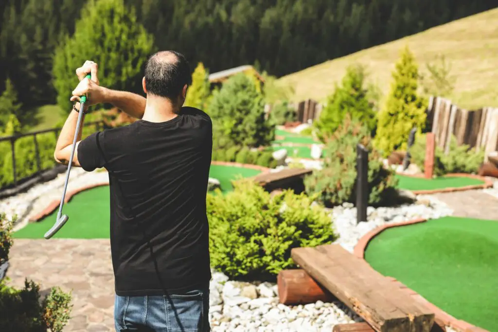 A person playing mini golf