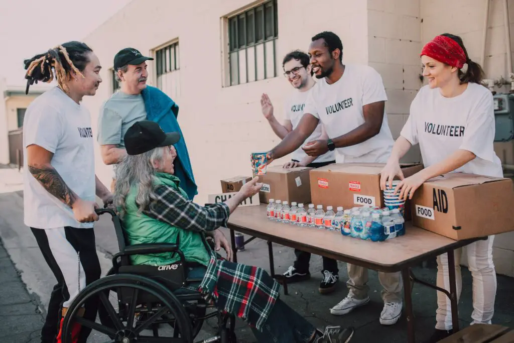 Group of volunteers assisting an elderly person