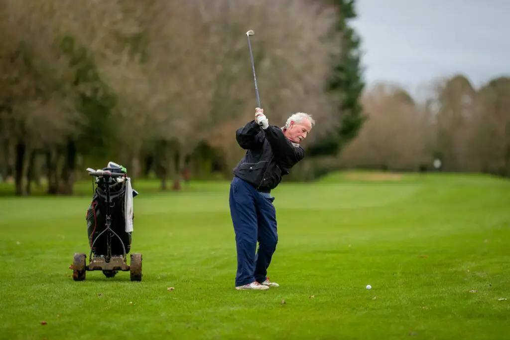 An elderly man playing golf