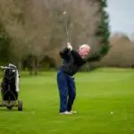 An elderly man playing golf