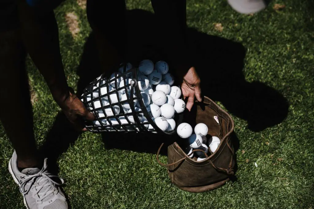 Person pouring golf balls in a bag