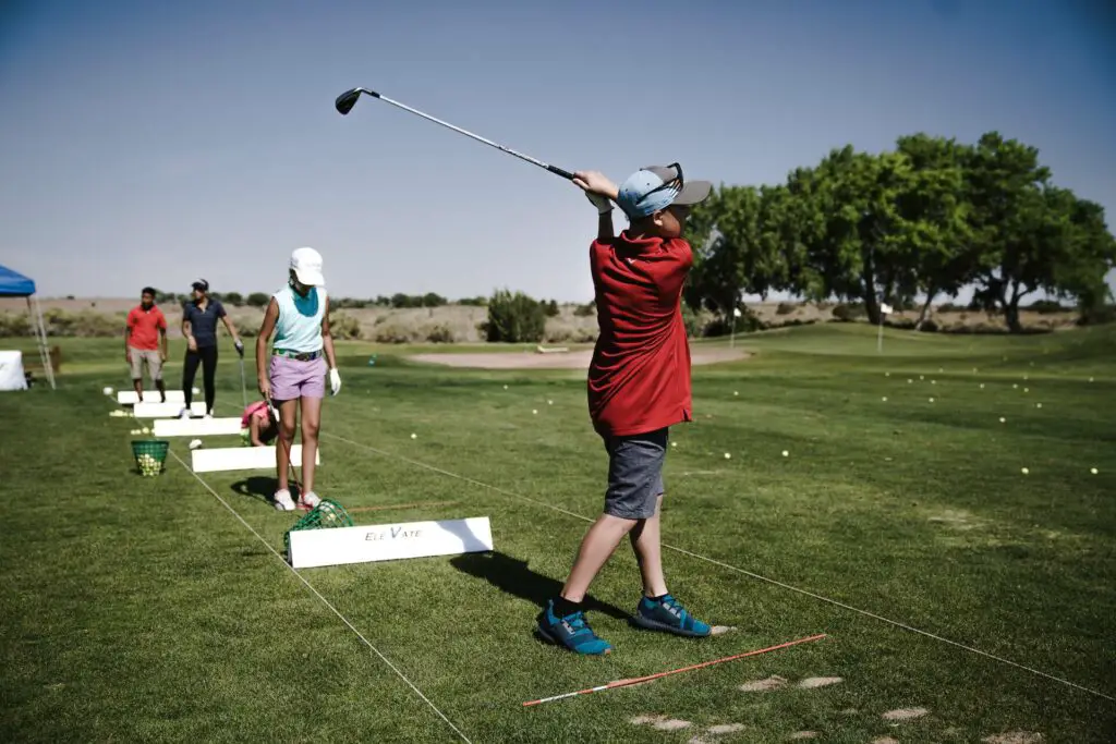 Person swinging a golf club on the field