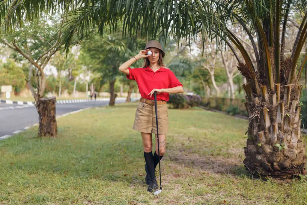 Woman holding a golf club and a ball