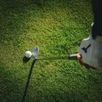 a person swinging a golf club
